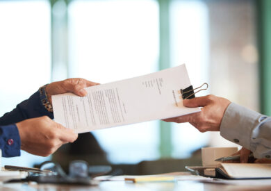 primer-plano-manos-pasando-contrato-al-empresario-irreconocible-l